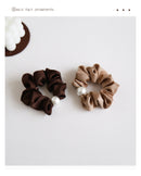 Close-up of faux pearl detail on wine red hair tie