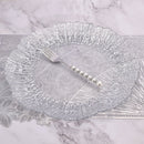 Hand holding dinner fork against soft neutral linen background
