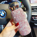 Tumbler in car cup holder with seatbelt visible for travel context