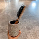 Hand holding hairbrush mid-use — emphasizing comfort and grip design