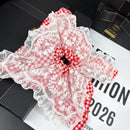 Red lace mesh hair tie wrapped around a wrist as a fashion accessory