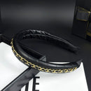 Close-up of metal chain attachment point on black leather base