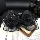 Lifestyle shot of black shark clip securing low bun on model's hair