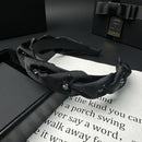 Black satin hair band styled on model's head with voluminous crown lift