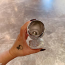 White tumbler in hand with sleeve pushed up — emphasizing ergonomics and scale