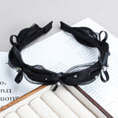 Lifestyle image: model wearing heather gray mesh headband while applying facial serum