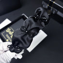 Close-up of black crystal embellishment on satin bow