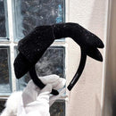 Black velvet headband styled with loose waves and silk pajamas, lifestyle context