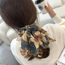 Hair tie wrapped into a loose ponytail on natural brown hair