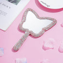 Front view of SUUMEE crystal handheld mirror in champagne lip shape on white background