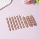 Stacked wooden brush handles in white and rose red showing uniform proportions and polish