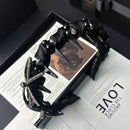 Front view of black satin bow headband with crystal accents on white background