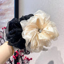 Front view of ivory organza bow hair tie on white background