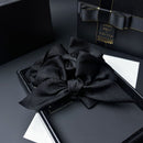 Black claw clip held open to show internal spring mechanism and fabric coverage