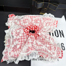 Close-up detail of irregular lace trim and mesh texture on red hair tie