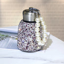 Tumbler with condensation-free exterior next to ice cubes — cold performance visual