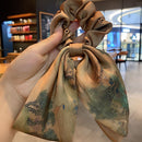 Close-up of ink-wash crane motif printed on soft satin hair tie fabric