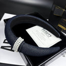 Front view of pearl-embellished denim headband on white background