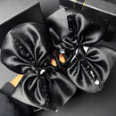 Close-up of embroidered star motif on black satin claw clip