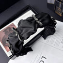 Black satin hair band with ruffled bow and bubble detail on white background