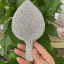 Lifestyle shot: mirror resting beside lipstick and compact on vanity table