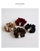 Side angle showing elastic stretch and seam reinforcement on beige hair tie